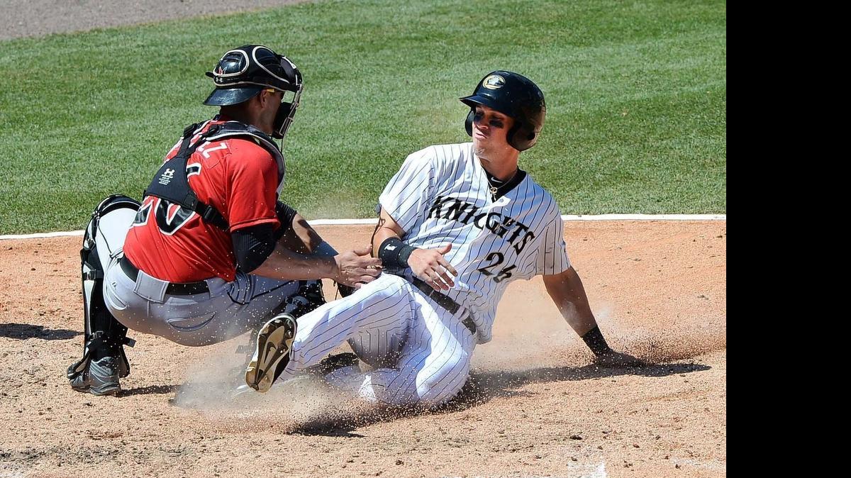 
The Knights’ Tyler Colvin slides safely at home to score as Indianapolis’ catcher Tony Sanchez makes the tag too late Sunday at BB&T BallPark. The Knights won 13-1.
