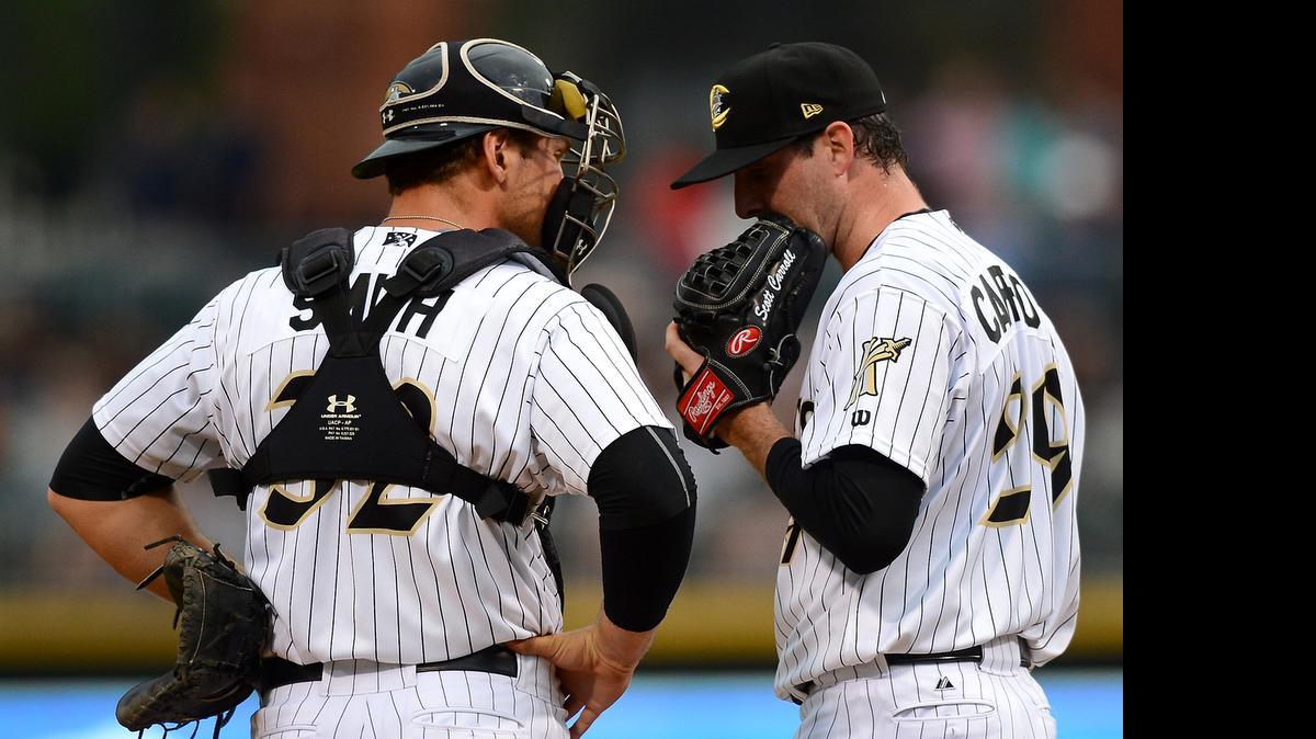 
Charlotte Knights catcher Kevan Smith, left, and pitcher Scott Carroll, right, have a conference at the mound during action vs the Gwinnett Braves at BB&T BallPark on April 17, 2015.
