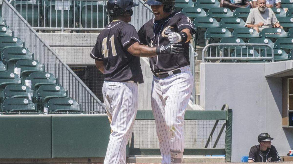 Charlotte Knight Matt Tuiasosopo (18), right, is congratulated by Dayan Viciedo (41) at home plate after he hit a two-run homer in the bottom of the fourth at BB&T BallPark.