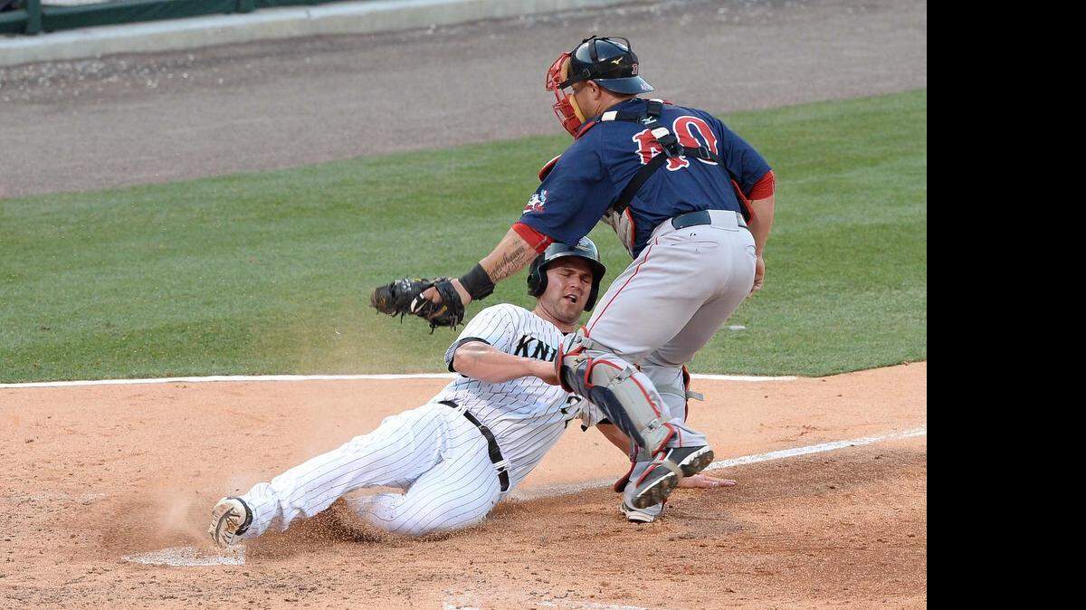 
Charlotte Knights runner Matt Davidson on left, gets tagged out at home plate by Pawtucket Red Sox catcher Humberto Quintero on right, during Tuesday night's game played at BB&T Ballpark, June 16,2015.
