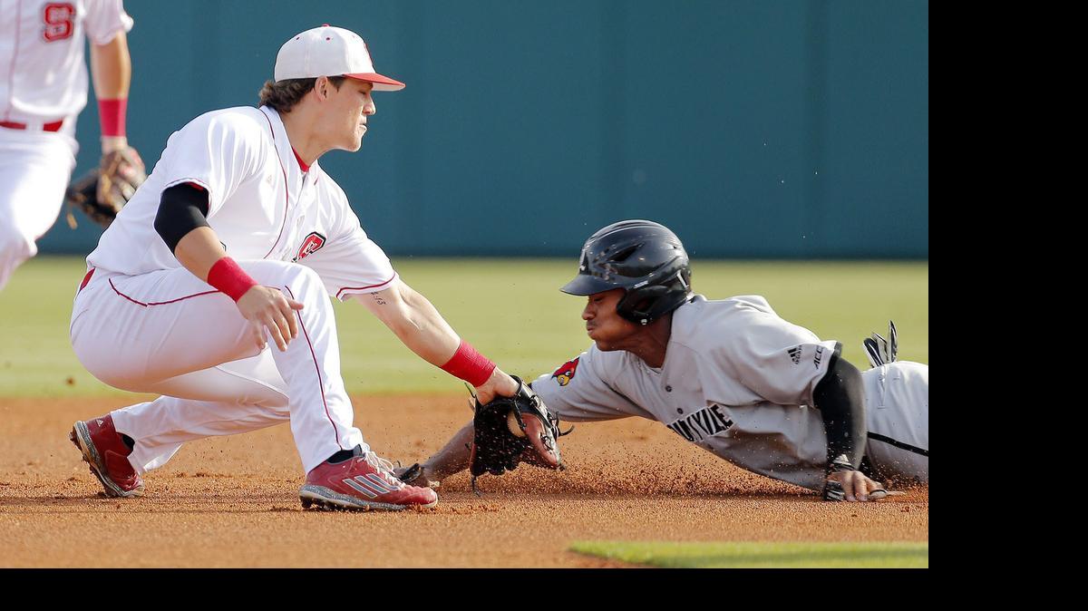 
NC State's Logan Ratledge (6) tries to tag Louisville's Corey Ray (2) out as he slides into second during the first inning of an ACC college baseball game played between Louisville and N.C. State at Doak Field on the N.C. State campus in Raleigh on May 14, 2015. Ray was ruled safe.

