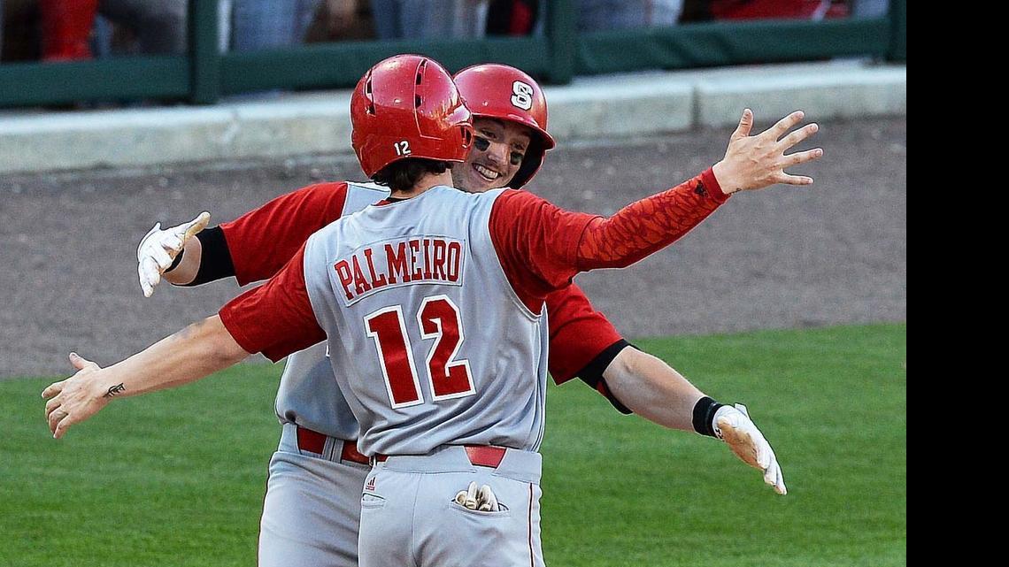 
N.C. State's runner Andrew Knizner (11), hugs teammate Preston Palmeiro (12) at home plate after Knizner scored a home run in the third inning during  a game played at BB&T Ballpark, March 31, 2015.

