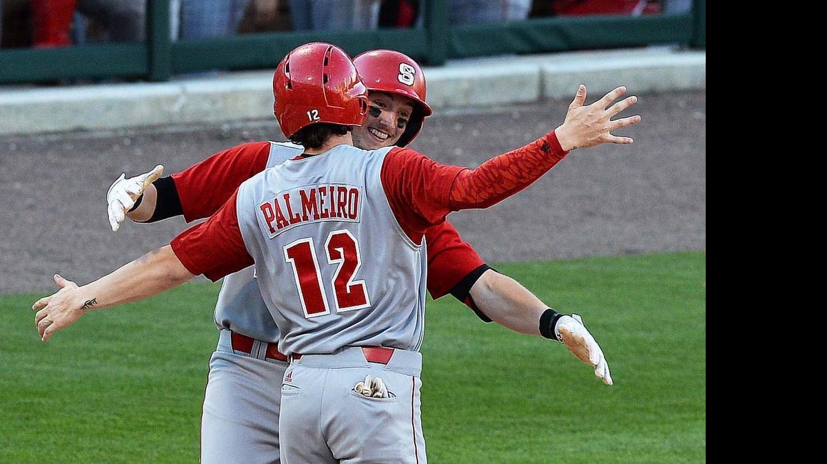 
N.C. State's runner Andrew Knizner (11), hugs teammate Preston Palmeiro (12) at home plate after Knizner scored a home run in the third inning during  a game played at BB&T Ballpark, March 31, 2015.
