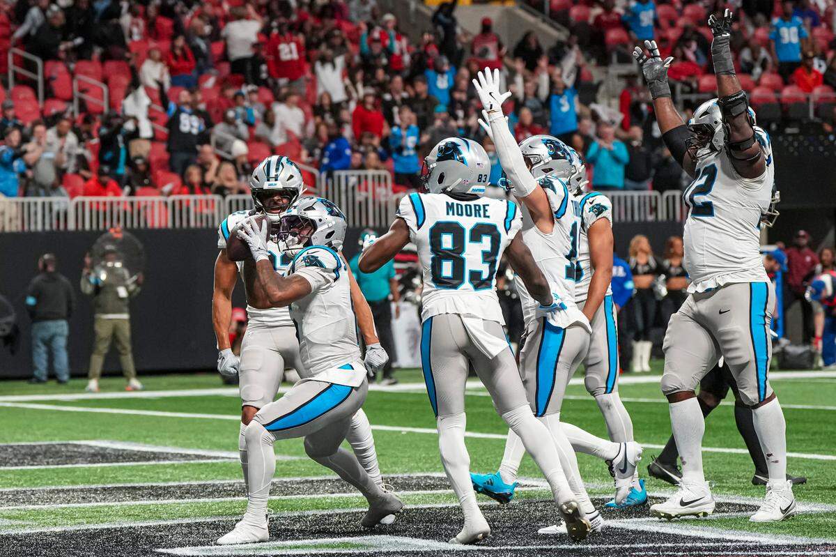 Carolina Panthers running back Miles Sanders (6) reacts with teammates after scoring the winning touchdown against the Atlanta Falcons in Sunday’s overtime at Mercedes-Benz Stadium.