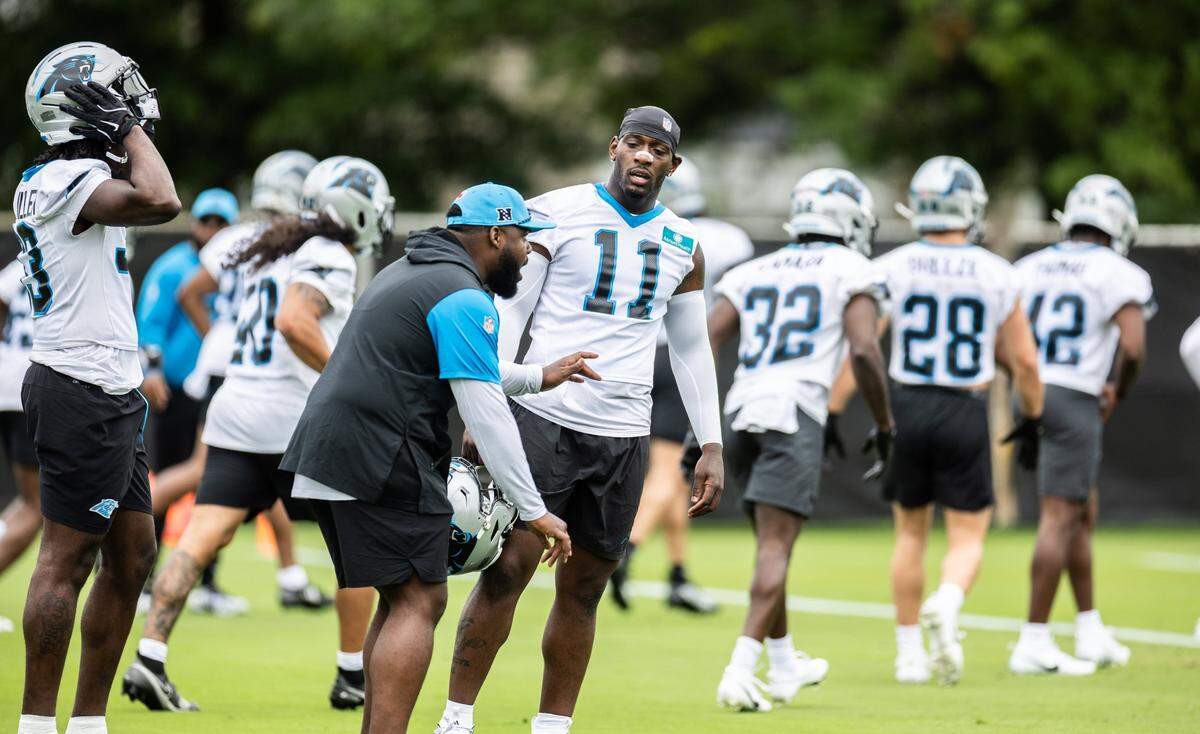 Carolina Panthers Nic Scourton talks to OLB coach AC Carter during the Carolina Panthers Rookie Minicamp in Charlotte, N.C., on Saturday, May 10, 2025.