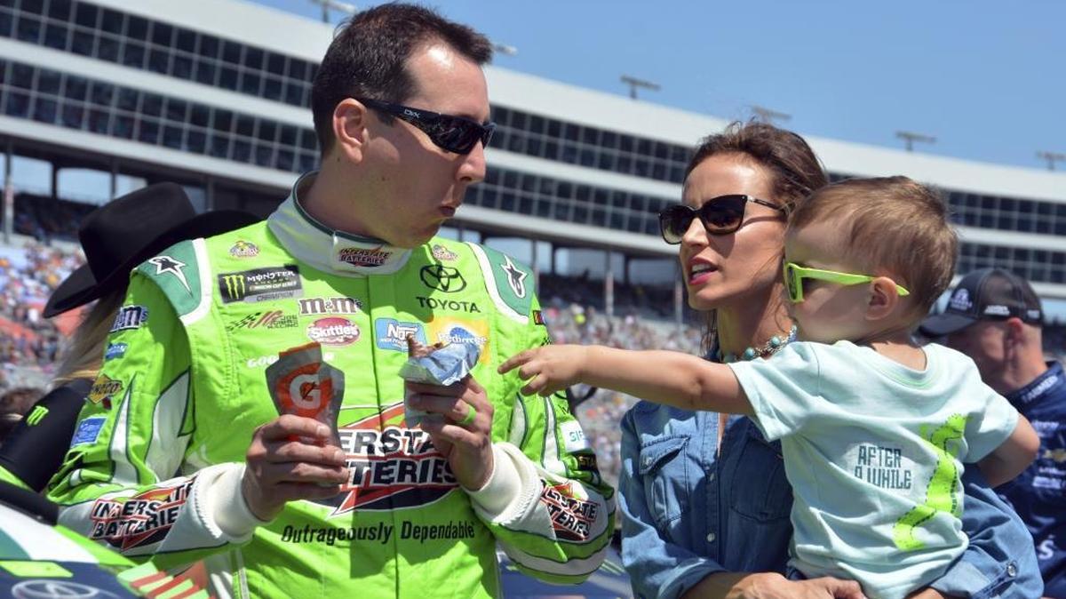 In this April 9, 2017, file photo, Kyle Busch jokes with his son Brexton, right, as he talks with his wife, Samantha, center, on pit road before the NASCAR Cup Series auto race at Texas Motor Speedway in Fort Worth, Texas.