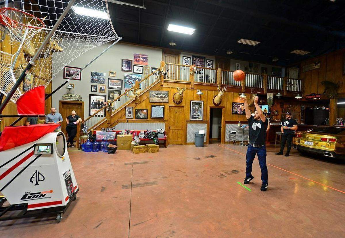 Austin Dillon effortlessly shoots free throw after free throw in his barn using the basketball machine his wife Whitney gave him as a wedding present this past winter.