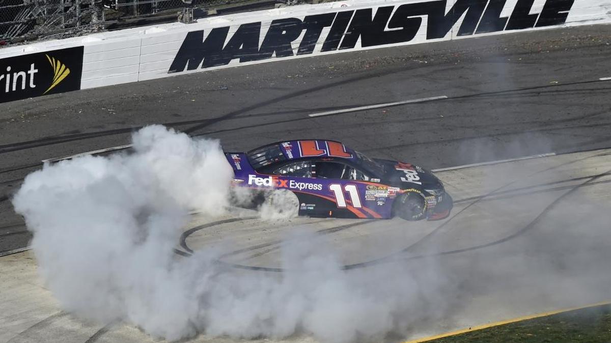 Denny Hamlin does a burnout after winning the NASCAR Sprint Cup Series auto race at Martinsville Speedway in Martinsville, Va., on March 29, 2015.