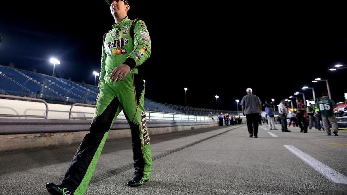 Kyle Busch walks on the grid during Friday’s qualifying for the NASCAR Sprint Cup Series Ford EcoBoost 400 at Homestead-Miami Speedway.