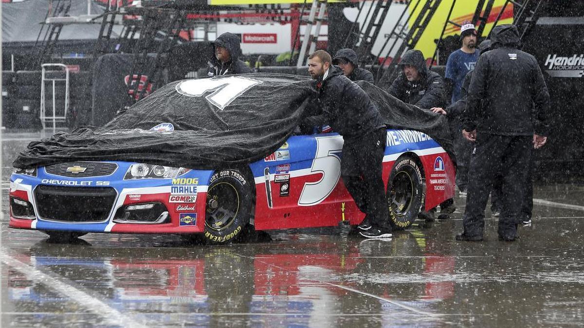 Crew members push driver Kasey Kahne’s car through the garage area at Charlotte Motor Speedway in Concord on Friday before the scheduled start of the Sprint Showdown auto race later today. Activities at the track have been were moved to Saturday because of rain in the area.