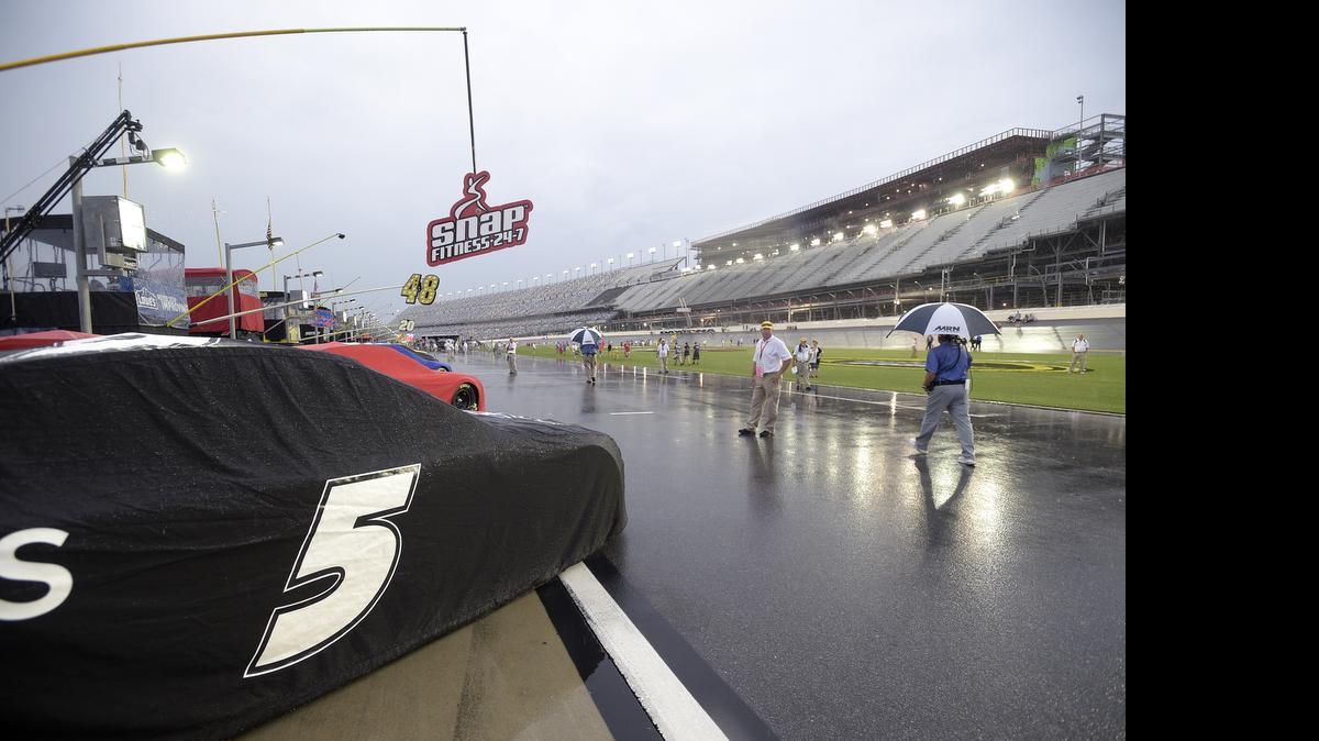 
Race cars sit covered on pit road during a rain shower before a NASCAR Sprint Cup series auto race at Daytona International Speedway in Daytona Beach, Fla., Sunday, July 5, 2015. 
