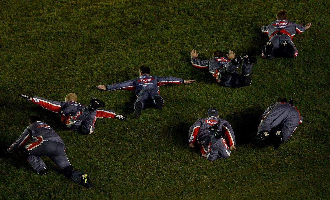 NASCAR driver Austin Dillon leads his team in doing a head first slide into the infield grass as they celebrate winning the Coca-Cola 600 at Charlotte Motor Speedway on Monday, May 29, 2017.