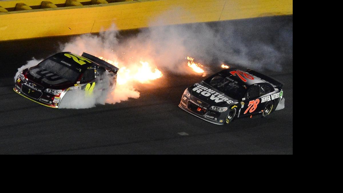 
NASCAR Sprint Cup Series driver Jeff Gordon's (24) car kicks up flames after an accident with Martin Truex Jr. (78) and Greg Biffle (16) during the 2014 NASCAR Sprint All-Star Race at Charlotte Motor Speedway in Concord.
