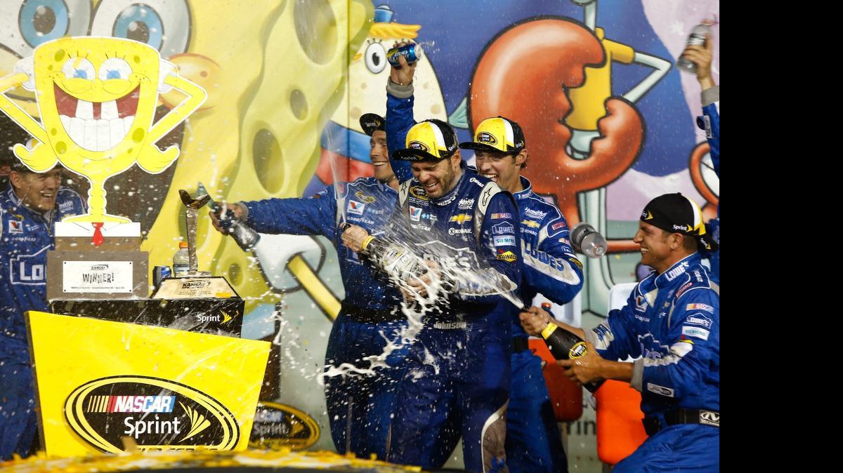 
Jimmie Johnson, driver of the #48 Lowe's Chevrolet, celebrates with champagne in Victory Lane after winning the NASCAR Sprint Cup Series SpongeBob SquarePants 400 at Kansas Speedway on May 9, 2015 in Kansas City, Kansas. 

