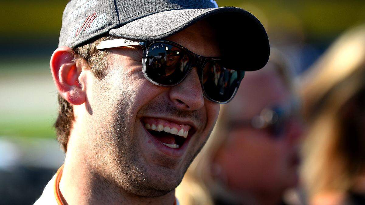 NASCAR driver Daniel Suarez laughs with passerby along pit road prior to the start of the NASCAR Monster Energy Open on Saturday, May 20, 2017.