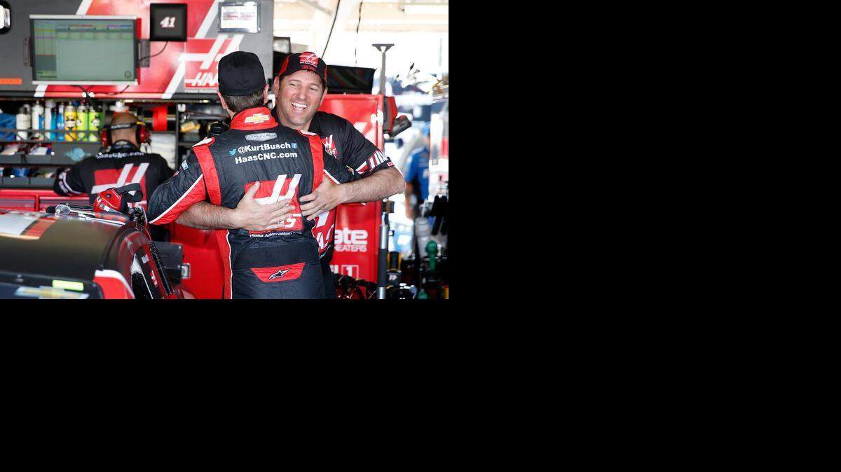 
A crew member on his Stewart-Haas Racing team embraces Kurt Busch on Friday in the garage at Phoenix International Raceway in Busch’s first day back since serving a suspension.
