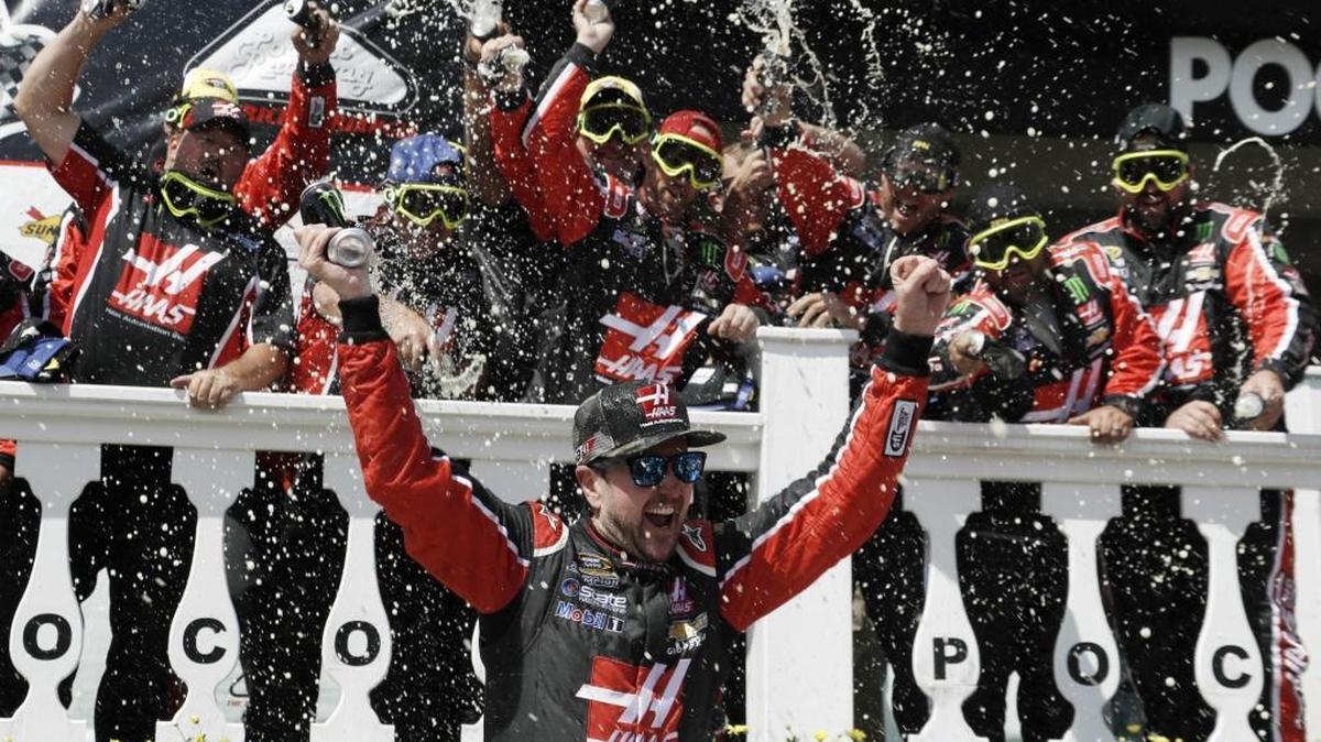 Kurt Busch celebrates with his team after winning Monday’s Sprint Cup series auto race at Pocono Raceway.