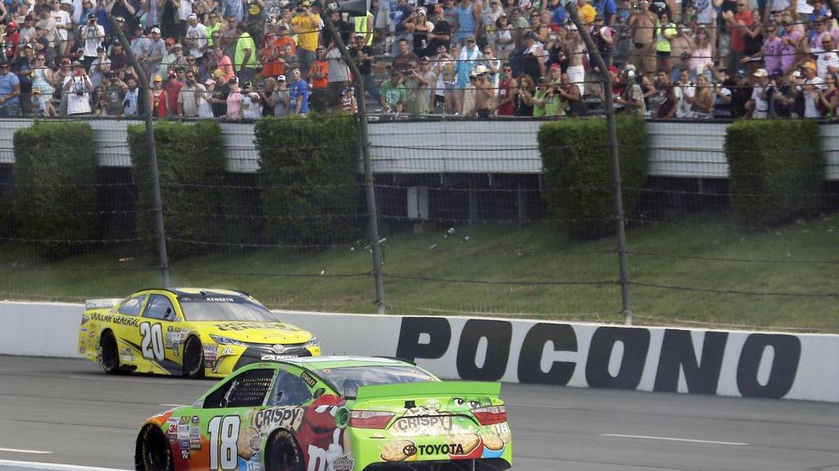 
Matt Kenseth (20) drives back up the front stretch past a coasting Kyle Busch (18) after winning the NASCAR Pocono 400 auto race, Sunday, Aug. 2, 2015, in Long Pond, Pa. Busch was leading the race when he ran out of fuel on the final lap.
