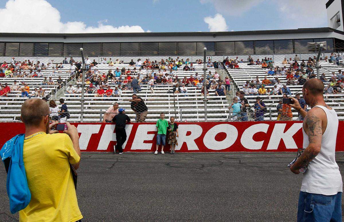 Race fans take photos by the track logo at the Rockingham Speedway before a 2012 NASCAR Truck Series race.