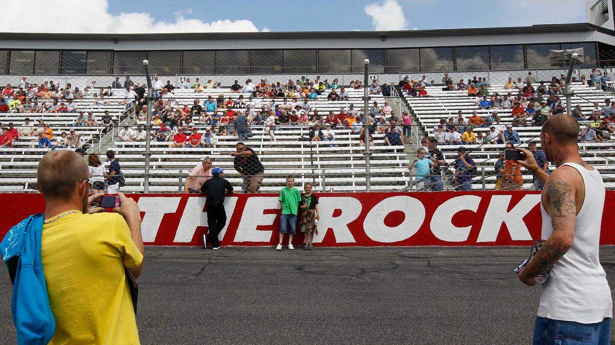 Race fans take photos by the track logo at the Rockingham Speedway before a 2012 NASCAR Truck Series race.