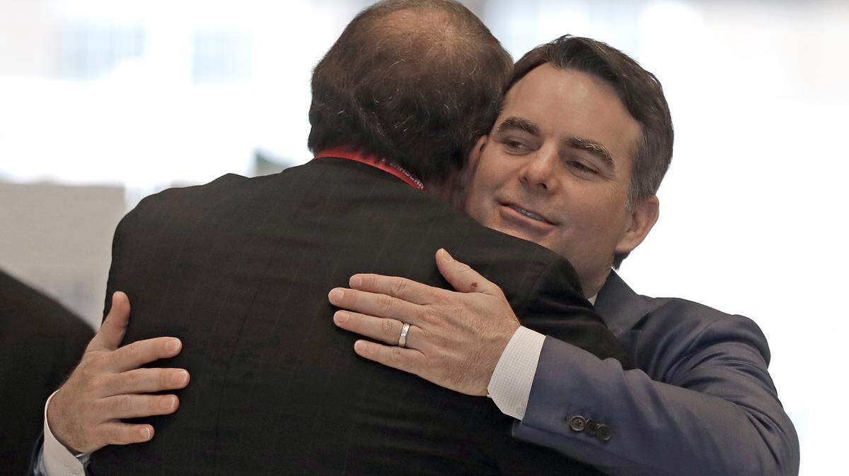 Jeff Gordon, right, gets a hug from Winston Kelley, left, executive director of the NASCAR Hall of Fame, after being named to the halls 2019 class, in Charlotte, N.C., Wednesday, May 23, 2018. (AP Photo/Chuck Burton)