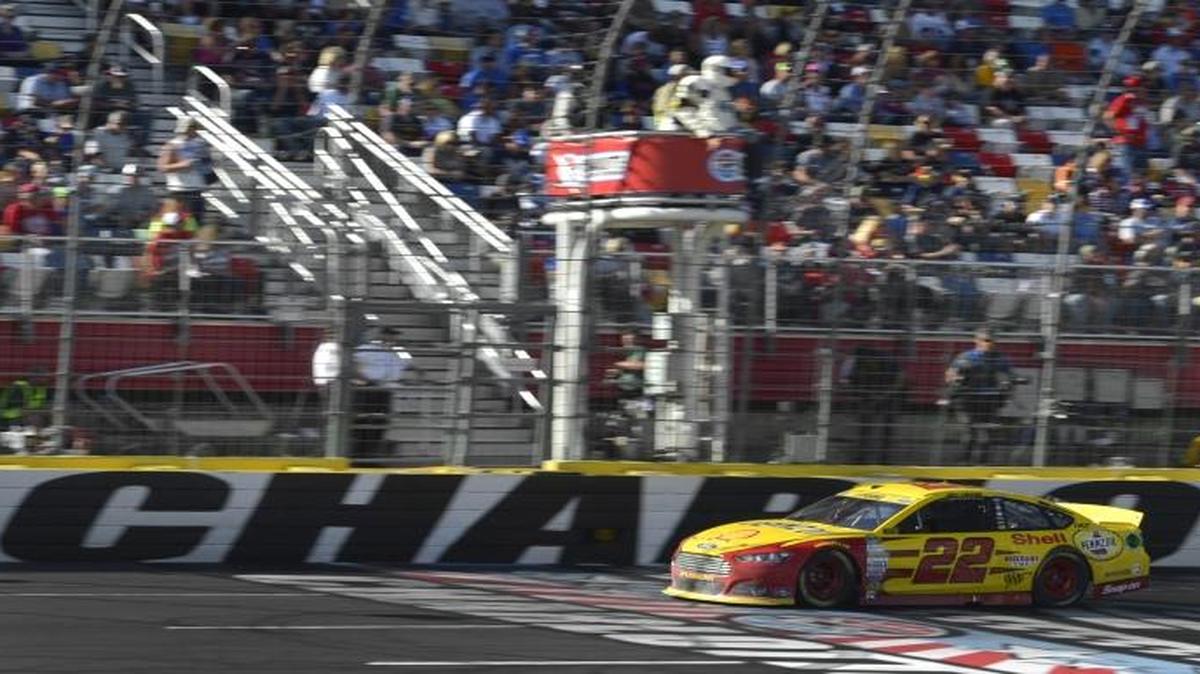 Joey Logano takes the checkered flag at the NASCAR Sprint Cup Bank of America 500 at Charlotte Motor Speedway in 2015.