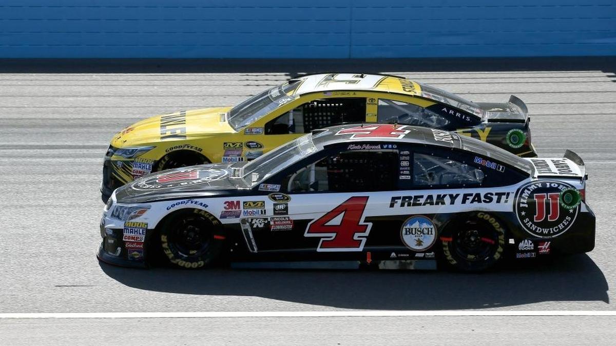 Kevin Harvick (4) and Carl Edwards, run side-by-side into the second turn during a NASCAR Sprint Cup Series auto race at Phoenix International Raceway Sunday, March 13, 2016, in Avondale, Ariz. Harvick defeated Edwards at the finish line. (AP Photo/Ross D. Franklin)
