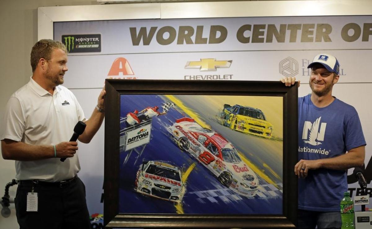 Chip Wile, left, president of International Speedway Corporation, presents Dale Earnhardt Jr. with a painting featuring three of his most memorable wins at Daytona International. The triumphs depicted in the painting, given to Earnhardt Friday, include his July 2001 victory that came 4 1/2 months after his father's fatal crash in the Daytona 500; his July 2010 win in the second-tier series in which he drove a No. 3 Chevrolet with a throwback paint scheme; and his February 2014 The Daytona 400.