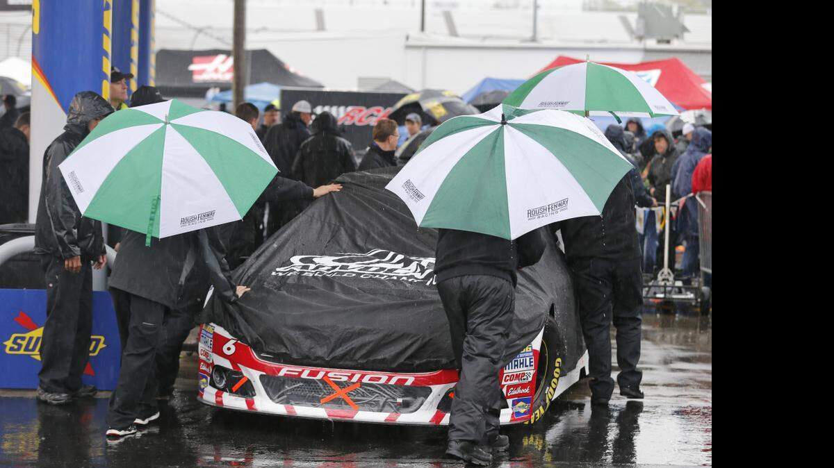 
The crew for Trevor Baine pushes his car to the inspection station as rain falls at Richmond International Raceway in Richmond, Va., Saturday, April 25, 2015. NASCAR has postponed the Sprint Cup Series Toyota Owners 400 at Richmond International Raceway until Sunday at 1 p.m. (FOX) due to rain.


