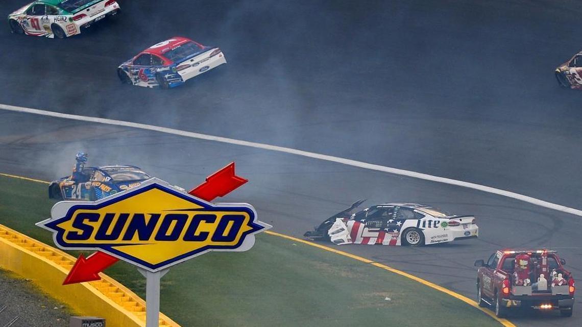 NASCAR driver Chase Elliott, left, watches from the door frame of his car as Brad Keselowski, right, heads toward him during a wreck heading into Turn 1 at Charlotte Motor Speedway during Sunday’s Coca-Cola 600.