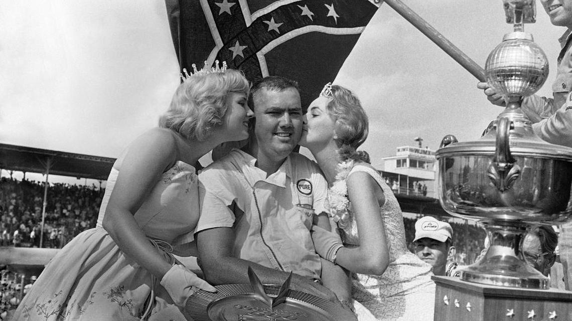 
Junior Johnson, at the 13th Annual Southern 500 at the Darlington (S.C.) International Raceway on Sept. 3, 1962, receives kisses from Miss Ginger Pointevint, Miss Sun Fun U.S.A., left, and Miss Joyce Brown, Miss Southern 500.
