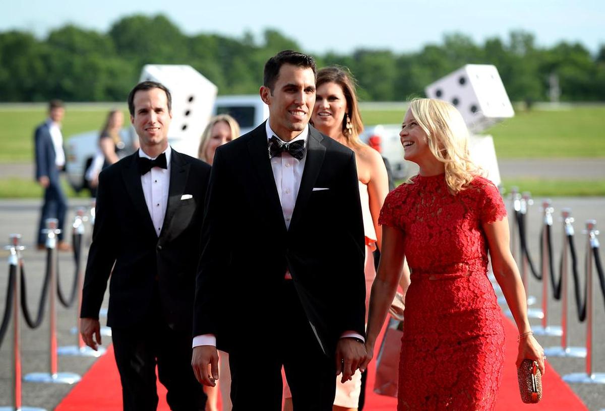 NASCAR driver Aric Almirola, center and his wife, Janice Almirola, right, walk the red carpet to the Catwalk for a Cause casino night and charity event at the Statesville Municipal Airport on Wednesday, May 18, 2017. The proceeds are going toward cancer research.