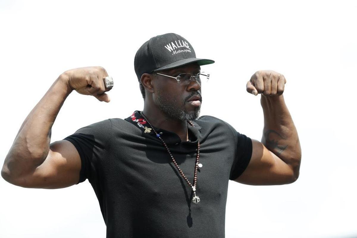 Ben Wallace, honorary pace car driver for Sunday’s NASCAR Cup Series race, flexes his muscles before the Consumers Energy 400 at Michigan International Speedway.