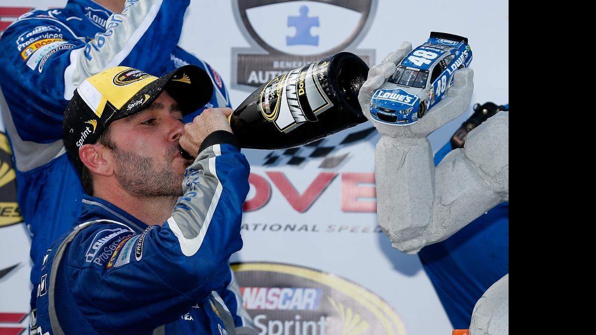 
Jimmie Johnson celebrates with champagne and the Miles the Monster trophy in Victory Lane after winning the NASCAR Sprint Cup Series FedEx 400 Benefiting Autism Speaks at Dover International Speedway on Sunday. May 31, 2015 in Dover, Del.
