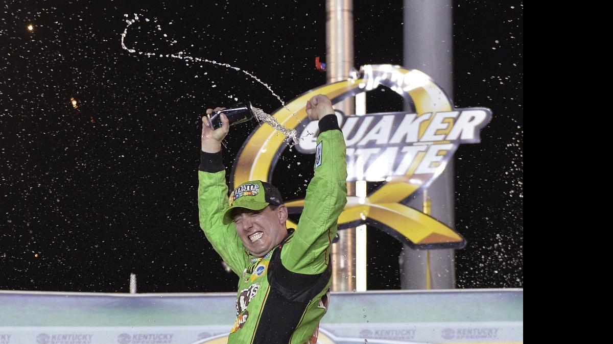 
Kyle Busch sprays his drink in Victory Lane after winning the NASCAR Sprint Cup series auto race at Kentucky Speedway in Sparta, Ky., Saturday, July 11, 2015. 
