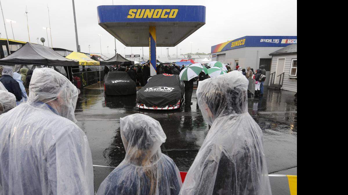 
Fans watch as rain falls on Sprint Cup cars waiting for inspection at Richmond International Raceway in Richmond, Va., Saturday, April 25, 2015. Persistent rain in Richmond postponed Saturday night’s Toyota Owners 400 until 1 p.m. Sunday (Fox). 


