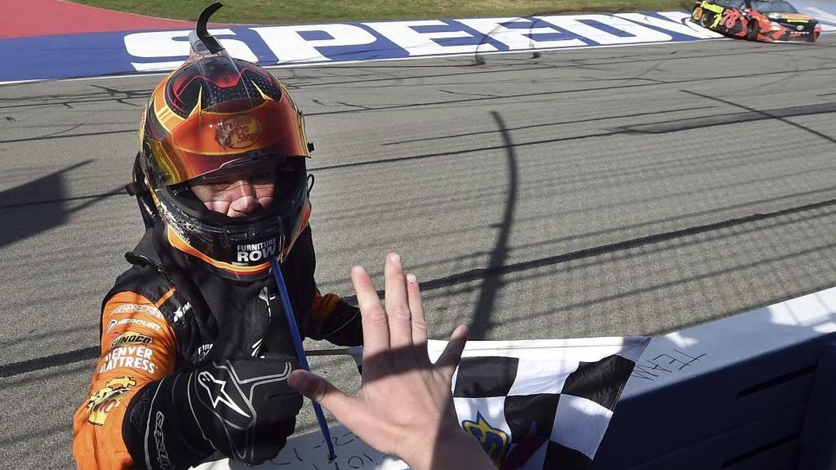 Defending NASCAR Cup Series champion Martin Truex Jr., left, acknowledges Joel Cram, 12 from Anna, Texas, after Joel handed Truex the checkered flag for Sunday’s Auto Club 400 race in Fontana, Calif. With Truex’s playoff ticket punched, the No. 78 team can be aggressive hasing stage points and wins the rest of the season.