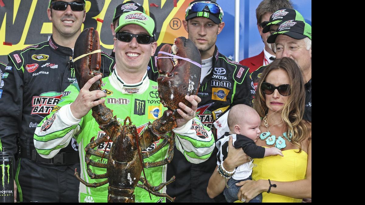 
Kyle Busch holds the Loudon lobster trophy in Victory Lane, as his wife, right, Samantha holding son Brexton looks on, after winning the NASCAR Sprint Cup series auto race at New Hampshire Motor Speedway, Loudon, N.H., Sunday, July 19, 2015 
