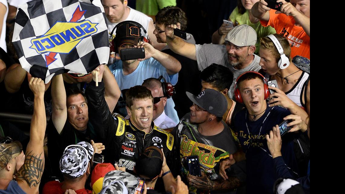 
NASCAR Sprint Cup Series driver Carl Edwards celebrates his victory in the Coca-Cola 600 with fans in the grandstand at Charlotte Motor Speedway on Sunday, May 24, 2015.
