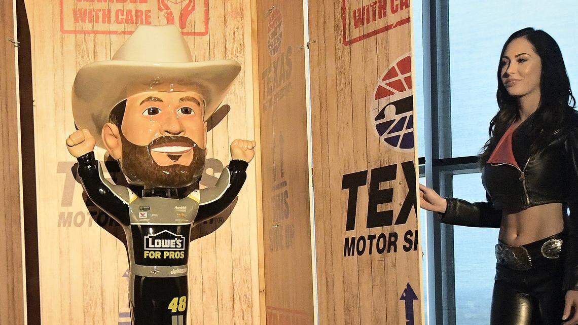 Great American Sweethearts members Alyssa Moore, left, and Hope Beel unveil  a large bobblehead of seven-time champion in the Monster Energy NASCAR Cup Series driver Jimmie Johnson at Texas Motor Speedway in Fort Worth, TX, Wednesday, Feb. 28, 2018.