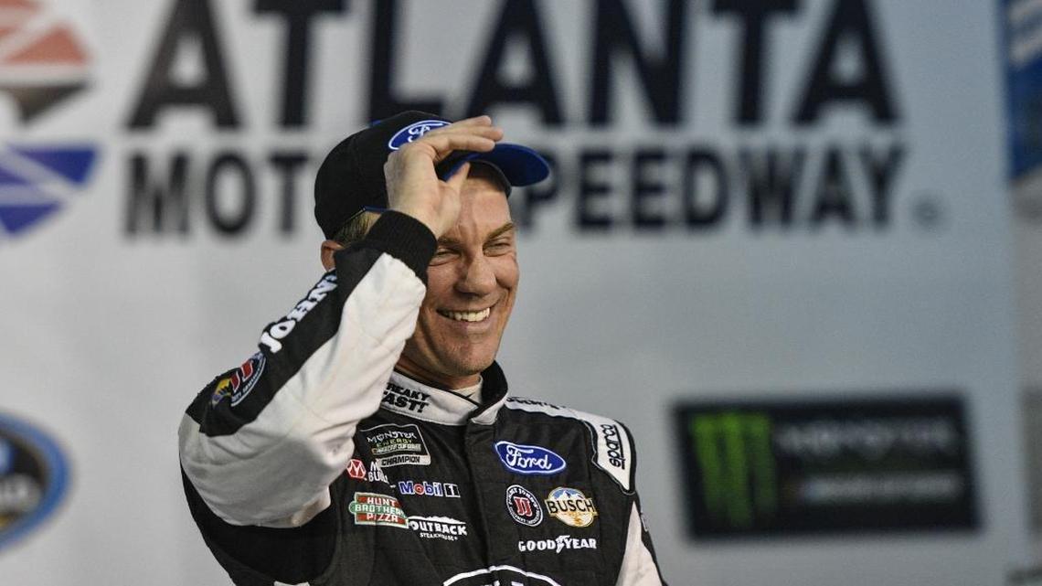Kevin Harvick stands in Victory Lane after winning the pole Friday for Sunday’s NASCAR Cup series race at Atlanta Motor Speedway.