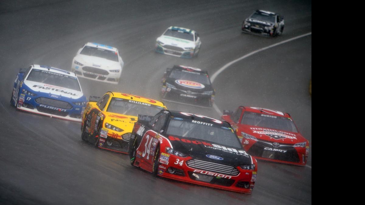 
Brett Moffitt, driver of the No. 34 Dockside Logistics Ford, leads a pack of cars as it begins to rain during the NASCAR Sprint Cup Series Quicken Loans 400 at Michigan International Speedway on Sunday, June 14, 2015 in Brooklyn, Mich.
