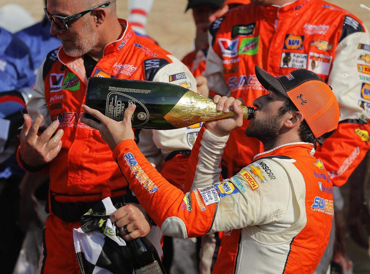Chase Elliott takes a sip of champagne after winning a NASCAR CupSeries auto race, Sunday, Aug. 5, 2018, in Watkins Glen, N.Y. (AP Photo/Julie Jacobson)