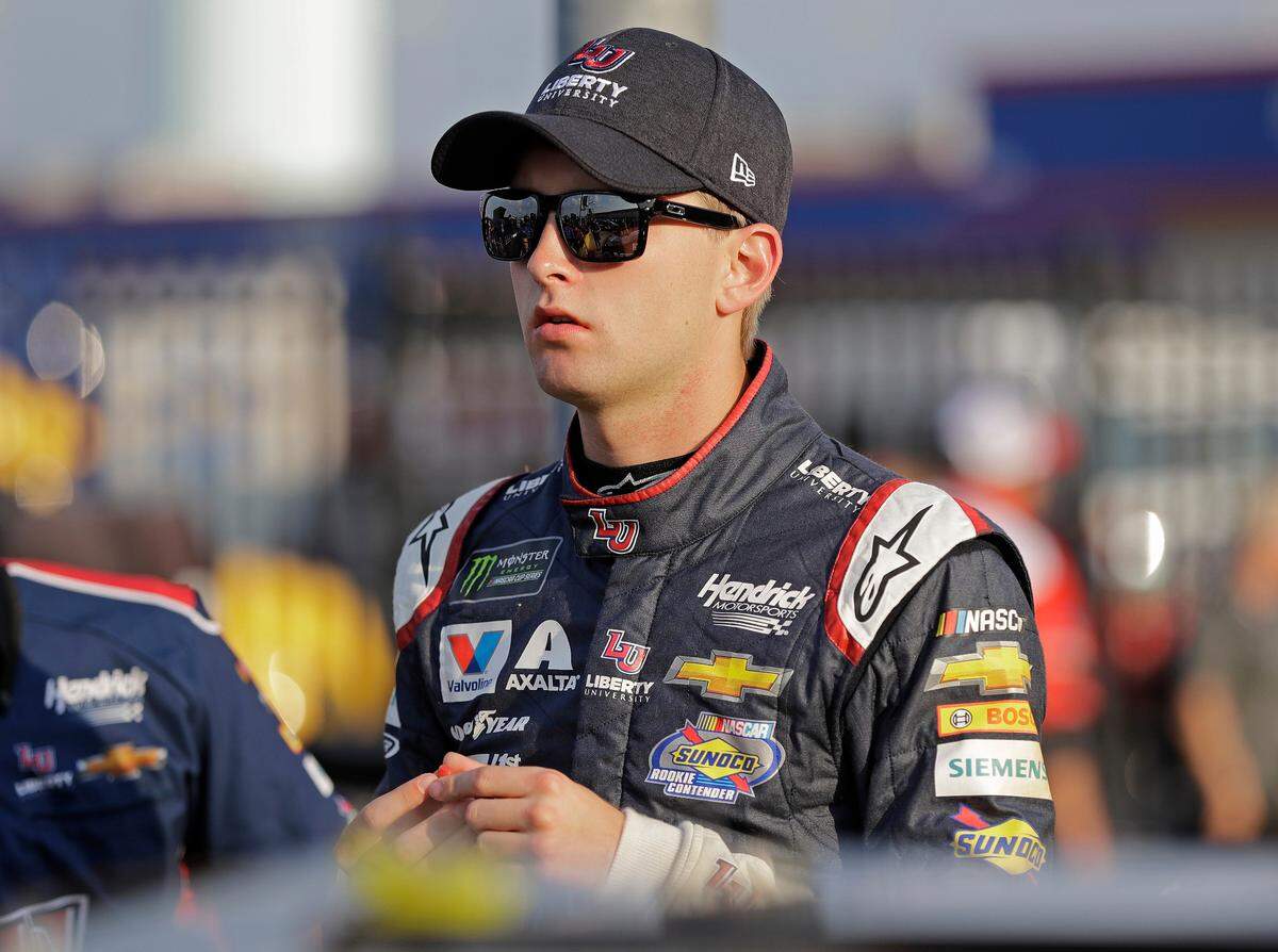 William Byron waits by his car before qualifying for the NASCAR Cup series auto race at Charlotte Motor Speedway in Charlotte, N.C., Thursday, May 24, 2018. (AP Photo/Chuck Burton)