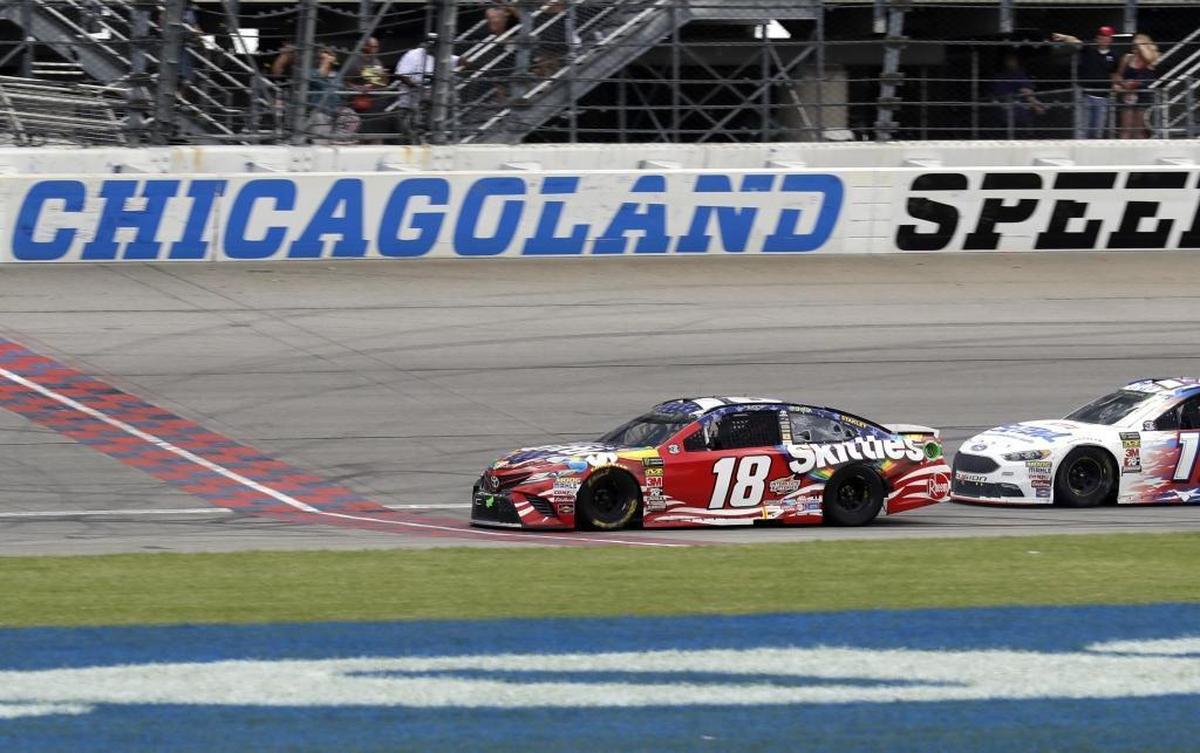 Kyle Busch (18) crosses the finish line to win Sunday’s Overton’s 400 NASCAR Cup Series race at Chicagoland Speedway in Joliet, Ill.