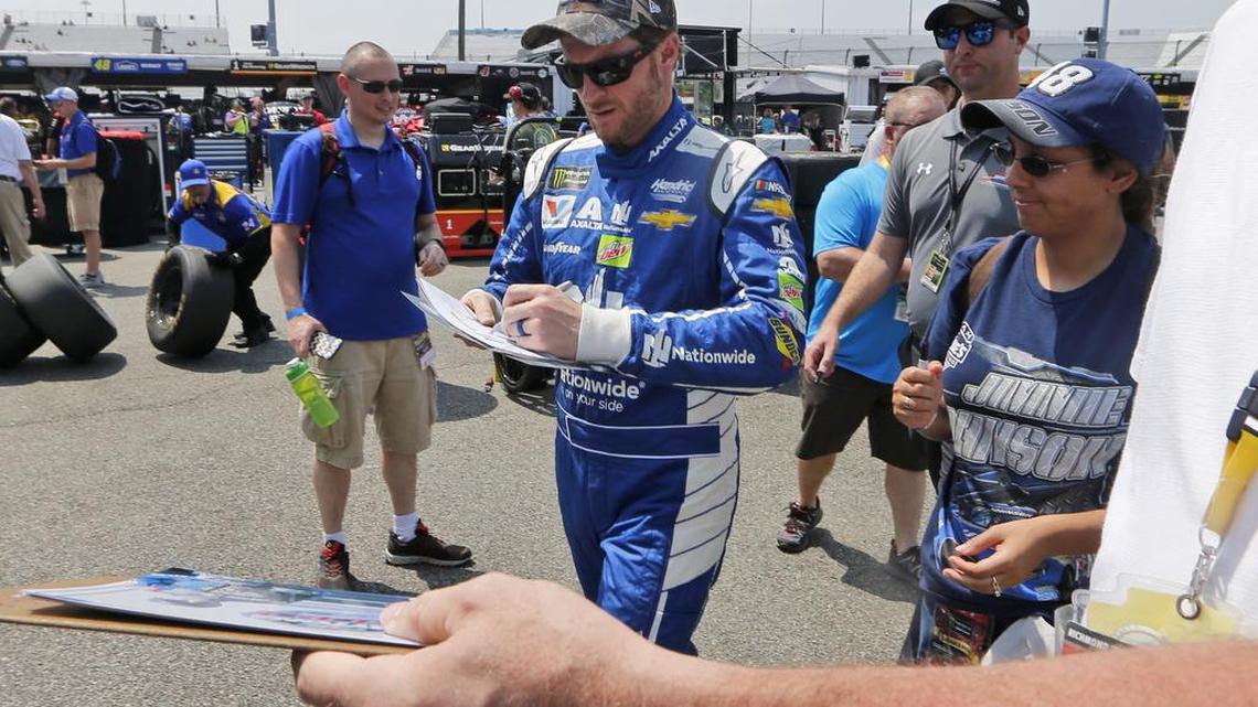Dale Earnhardt Jr., center, signs autographs for fans after practice for a NASCAR Cup Series race at Richmond International Raceway in Richmond, Va., Saturday, April 29, 2017.