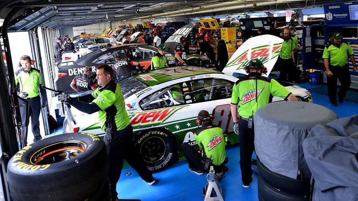 Members of driver Dale Earnhardt Jr.’s team make adjustments to the car during practice Saturday.