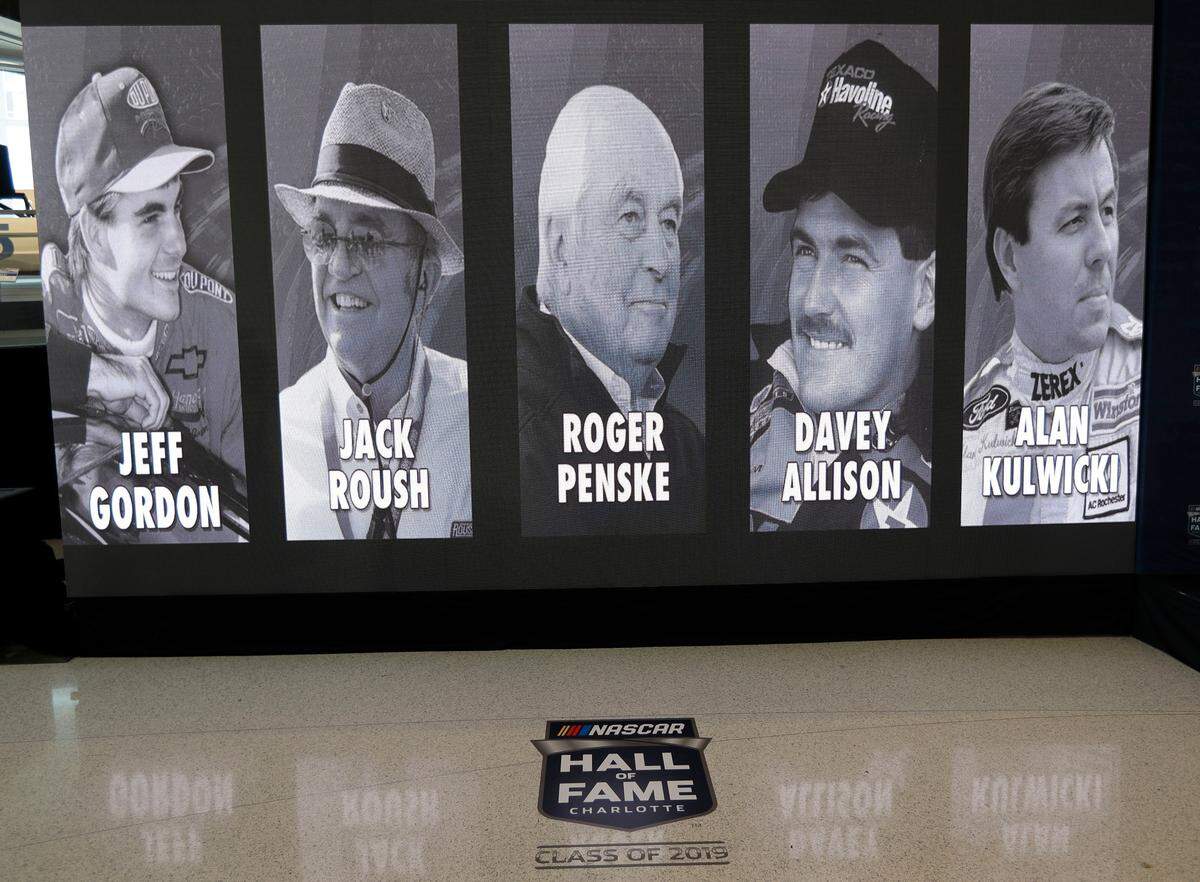 The 2019 class of the NASCAR Hall of Fame, from left, Jeff Gordon, Jack Roush, Roger Penske, Davey Allison and Alan Kulwicki are shown on display after an announcement in Charlotte, N.C., Wednesday, May 23, 2018. (AP Photo/Chuck Burton)