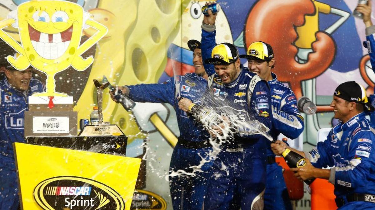 
Jimmie Johnson celebrates with champagne in Victory Lane after winning the NASCAR Sprint Cup Series SpongeBob SquarePants 400 at Kansas Speedway on May 9, 2015.
