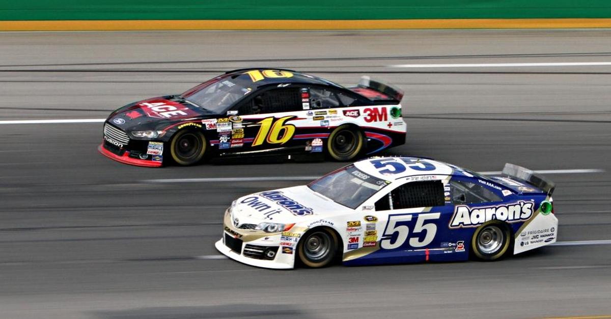 Drivers Greg Biffle, left, and Brian Vickers race through Turn 3 at Kentucky Speedway in Sparta, Ky.
